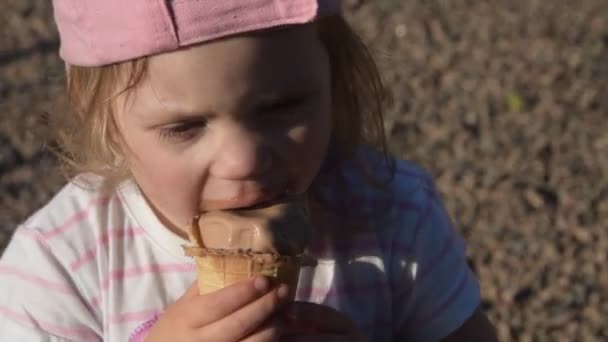 La niña comiendo helado de chocolate afuera — Vídeo de stock