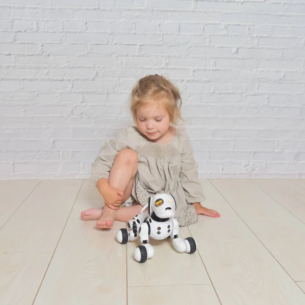 La niña jugando se encarga del robot perro — Foto de Stock