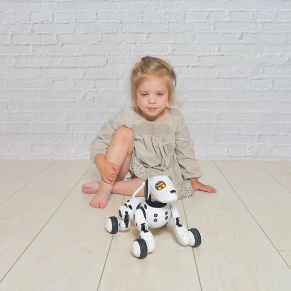 Oynayan kız bebek köpek robot ilgilenir — Stok fotoğraf