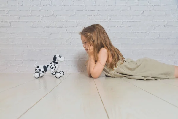 La niña jugando se encarga del robot perro — Foto de Stock