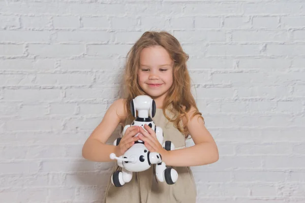 La niña jugando se encarga del robot perro — Foto de Stock