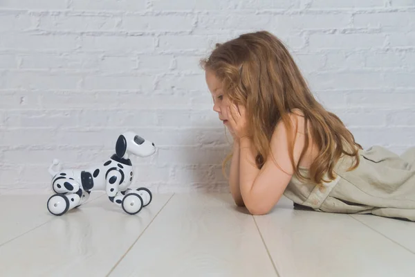 La niña jugando se encarga del robot perro — Foto de Stock
