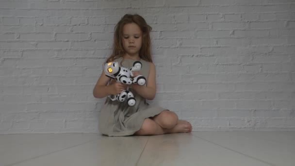 Le bébé fille joue prend soin du robot chien — Video