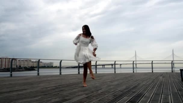 The waterfront girl in a white dress dancing — Stock Video