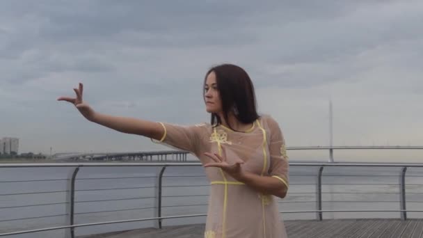 La chica frente al mar en un vestido blanco bailando — Vídeos de Stock