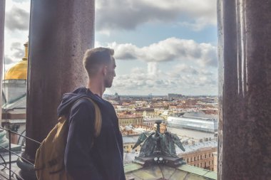 sakallı genç adam çatıdaki taş sütunların yanında dışarıda