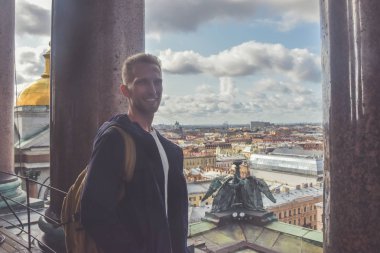 sakallı genç adam çatıdaki taş sütunların yanında dışarıda