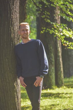 ağaçların arasında bir Parkta sakallı genç adam