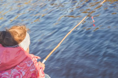 Nehir kıyısında balık tutan kız.