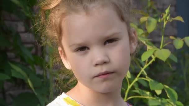 Una bambina tira fuori un fiore da annusare — Video Stock