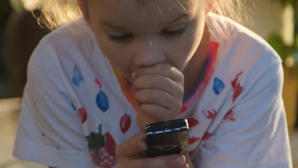 Una bambina sta messaggiando emotivamente al telefono fuori — Video Stock