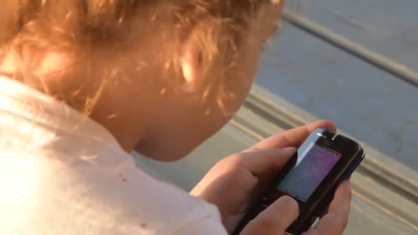 Una bambina sta messaggiando emotivamente al telefono fuori — Video Stock