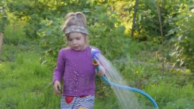Hortumlu ve sulu bir çocuk bahçeyi sulayabilir.