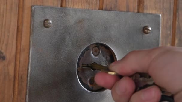 La mano abre las llaves de madera de la puerta cerca — Vídeos de Stock