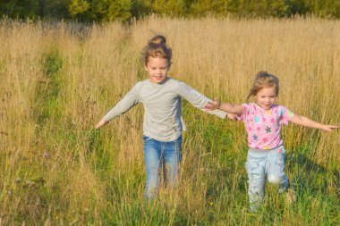 Güneşli yaz gününde bir çocuk tarlada çavdarla koşuyor.