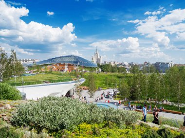 Moskova, Rusya - 03 Haziran 2018. Red Square yakınındaki Zaryadye peyzaj kentsel park. Çim ve çiçek yatak arasında yürüyüş insanlar. Konser salonu amfitiyatro ile bir cam kubbe.