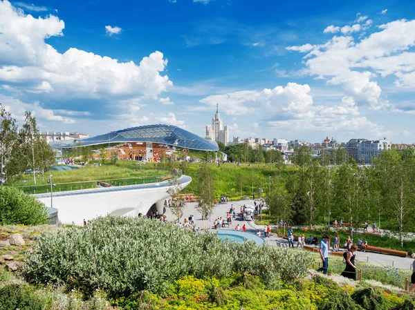 Moskova, Rusya - 03 Haziran 2018. Red Square yakınındaki Zaryadye peyzaj kentsel park. Çim ve çiçek yatak arasında yürüyüş insanlar. Konser salonu amfitiyatro ile bir cam kubbe.