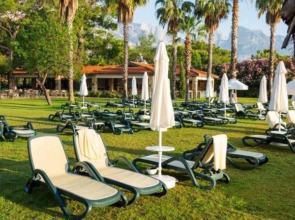 Otel, Türkiye'nin Güneydoğu bölümü için tipik sabahın erken saatlerinde. Sun'ın bahçesinde deniz kenarında şezlong vardır. Kemer, Türkiye.