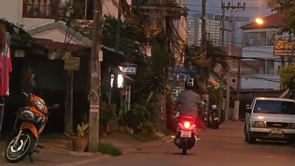 PATTAYA, THAILAND - 20 de outubro de 2012. A vida de rua habitual. Homem dirigindo moto, crianças brincando na rua . — Vídeo de Stock