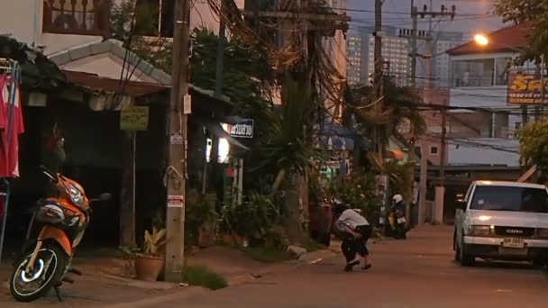 Pattaya, Tajlandia - października 20, 2012. Życie ulicy zwykle. Mężczyzna jadący motocyklem, dzieci bawiące się na ulicy. — Wideo stockowe
