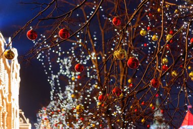 Moskova sokaklarında Noel ve yeni yıl kutlama için dekore edilmiştir. Ağaç parlak kırmızı ve sarı top ile. Sakız (ana mağaza) ampul arka plan ile. Rusya.