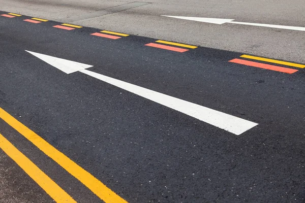 Road markings on the asphalt. Painted signs on the roadway for vehicle drivers. Dotted line and arrows. Singapore.