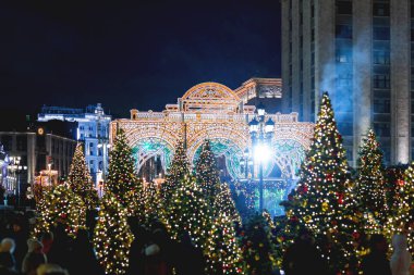 Moskova, Rusya - 24 Aralık 2017. Noel ve yeni yıl kutlama için dekore edilmiş Moskova tarihi merkezinde yürüyüş insanlar. Manezhnaya kare üzerinde ışık ampuller ile dekoratif kemer. 