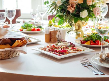 Tablo için düğün ziyafet çatal ve vazo çiçekleri ile görev yaptı. Salatalar, mezeler ve gözlük şarap ile.