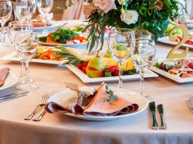 Tablo için düğün ziyafet çatal ve vazo çiçekleri ile görev yaptı. Salatalar, mezeler ve gözlük şarap ile.