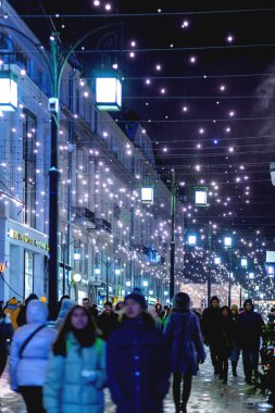 Moskova, Rusya - 24 Aralık 2017. İnsanlar Noel ve yeni yıl kutlamak için dekore edilmiş Moskova sokaklarında yürürken, insanlar.