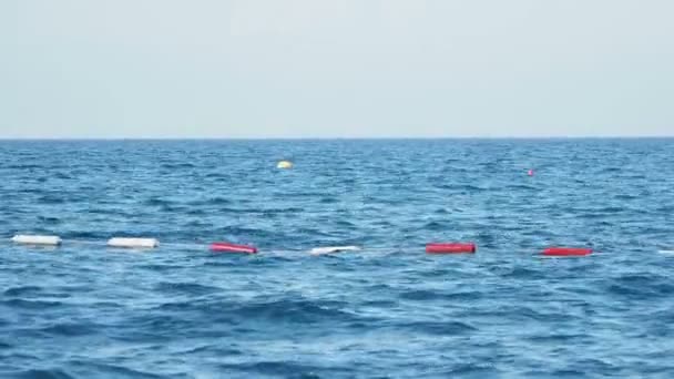 Bojen, die den sicheren Bereich zum Schwimmen einschränken und auf den Wellen schwingen. — Stockvideo