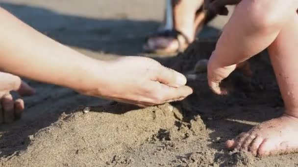 Bébé jouant avec les parents sur la plage. Les enfants sont pleins de sable. Jeux en plein air . — Video