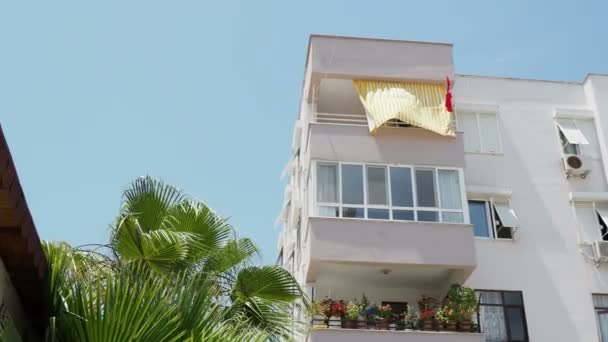 Balkon met kamerplanten en bloemen, gestreepte kleurrijke tent. Demre, Turkije. — Stockvideo