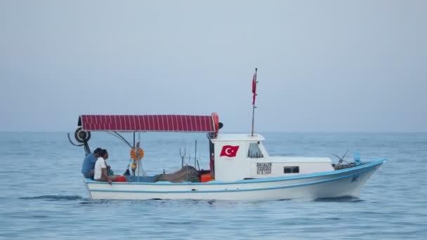 Κεμέρ, Τουρκία - Μαΐου 12, 2018. Οι άνδρες μιλούν στο μηχανοκίνητο σκάφος που κινείται. Όχημα που πλέει στη θάλασσα παρελθόν τις σημαδούρες. — Αρχείο Βίντεο