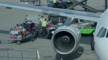 Boşaltma Bagaj havaalanında uçaktan. Nakliyeciler bavul konveyör bant kamyona vardiya.