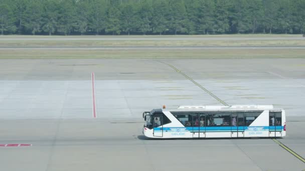 Ein spezieller Flughafenbus fährt auf dem Startplatz des Flughafens. Touristen fahren mit dem Bus ins Flugzeug. — Stockvideo