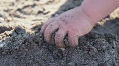 Bebek plajda oynayan. Çocuklar el kumla dolu. Açık hava oyunları.
