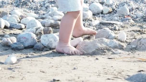 Bébé jouant avec des pierres sur la plage. Les enfants sont pleins de sable. Jeux en plein air . — Video