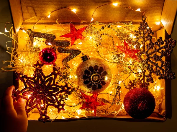 Kartonnen Doos Met Kerstmis Nieuwjaar Decoraties Gloeilampen Kleine Baby Raken — Stockfoto