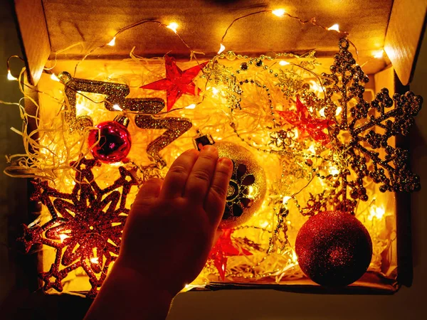 Kartonnen Doos Met Kerstmis Nieuwjaar Decoraties Gloeilampen Kleine Baby Aanraken — Stockfoto