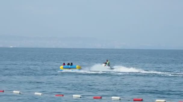 Kemer, Turkey - 12 Mayıs, turistler su cazibe - jet ski ile hamle Şişme kanepe içinde eğlenmek. — Stok video