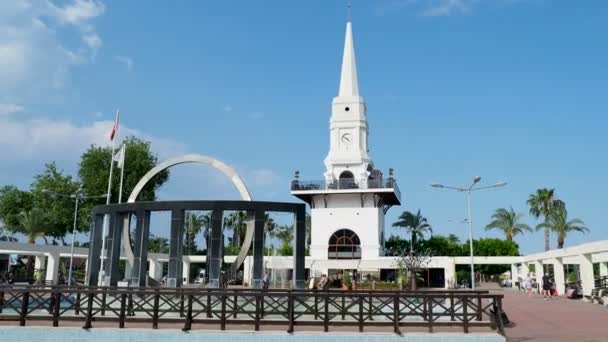 Kemer, Turkije - 14 mei 2018. Toeristen lopen op Ataturk plein in de buurt van witte klokkentoren en monument voor Mustafa Kemal Ataturk, President van Turkije, — Stockvideo