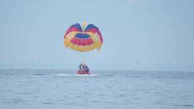 Kemer, Turkey - Mayıs 12, turist var eğlenceli su cazibe - parasailing. Adam paraşüt ile motorlu tekne ile hareket eder..