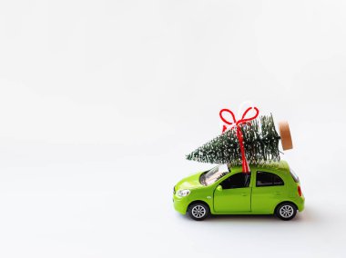 Yeşil oyuncak araba ile bağlı köknar ağacı çatıda. Noel ve yeni yıl arka plan metin için yer ile.