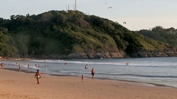 Phuket, Thailand - 25 oktober 2012. Mensen ontspannen op het strand van Nai Harn. Toeristen zijn zwemmen, wandelen, zon zwemmen, vliegen een paraglider. — Stockvideo