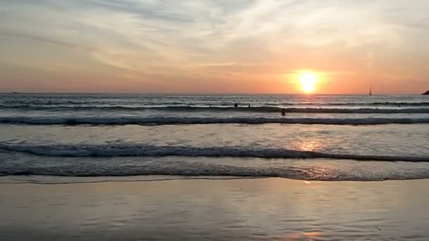 Phuket, Thaiföld - október 25, 2012. Emberek, úszás a tengerre a naplemente. Nai Harn beach. — Stock videók