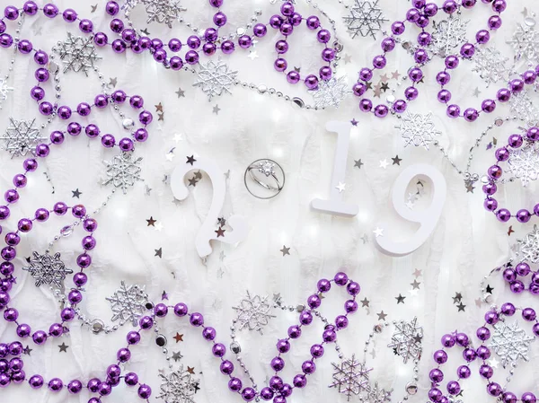 Noel ve yeni yıl arka plan numaraları 2019, Alyans elmas, menekşe süslemeleri ve ampuller ile.