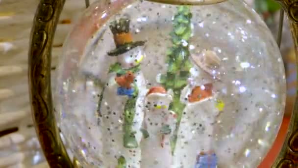 Three snowmen inside vintage snow globe with spangles. Christmas retro toy. — Stock Video