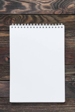 Ahşap arka plan ile not etmek. Açık beyaz sayfa sahte kullanılabilir. Office kaynağı notlar yapmak için ya da listeleri yapmak.