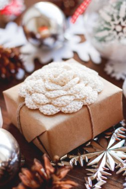 Noel ve yeni yıl arka plan sunar, kurdeleler, topları ve ahşap arka plan üzerinde farklı süslemeler ile. Tığ işi çiçek hediye Craft El yapımı ile kağıt sarma.